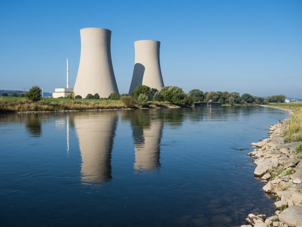 A body of water with two cooling towers in the background