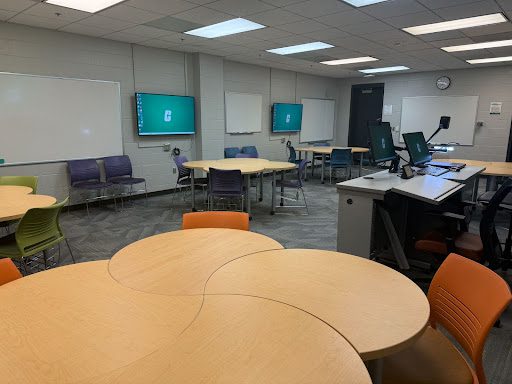 Fretwell 114 collaborative workspace with orange chairs and 4 connected circle tables.
